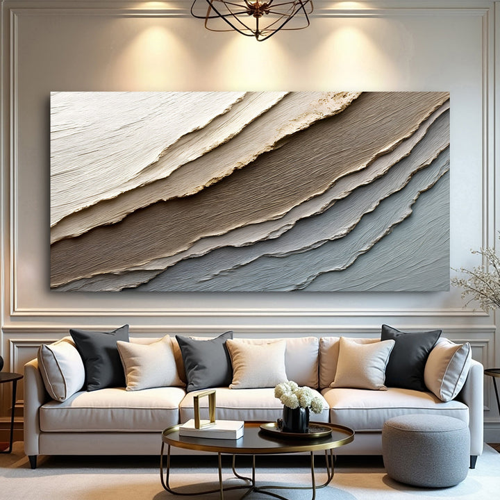 Quadro Camadas da Terra acima de sofá claro em sala com boiserie e lustre