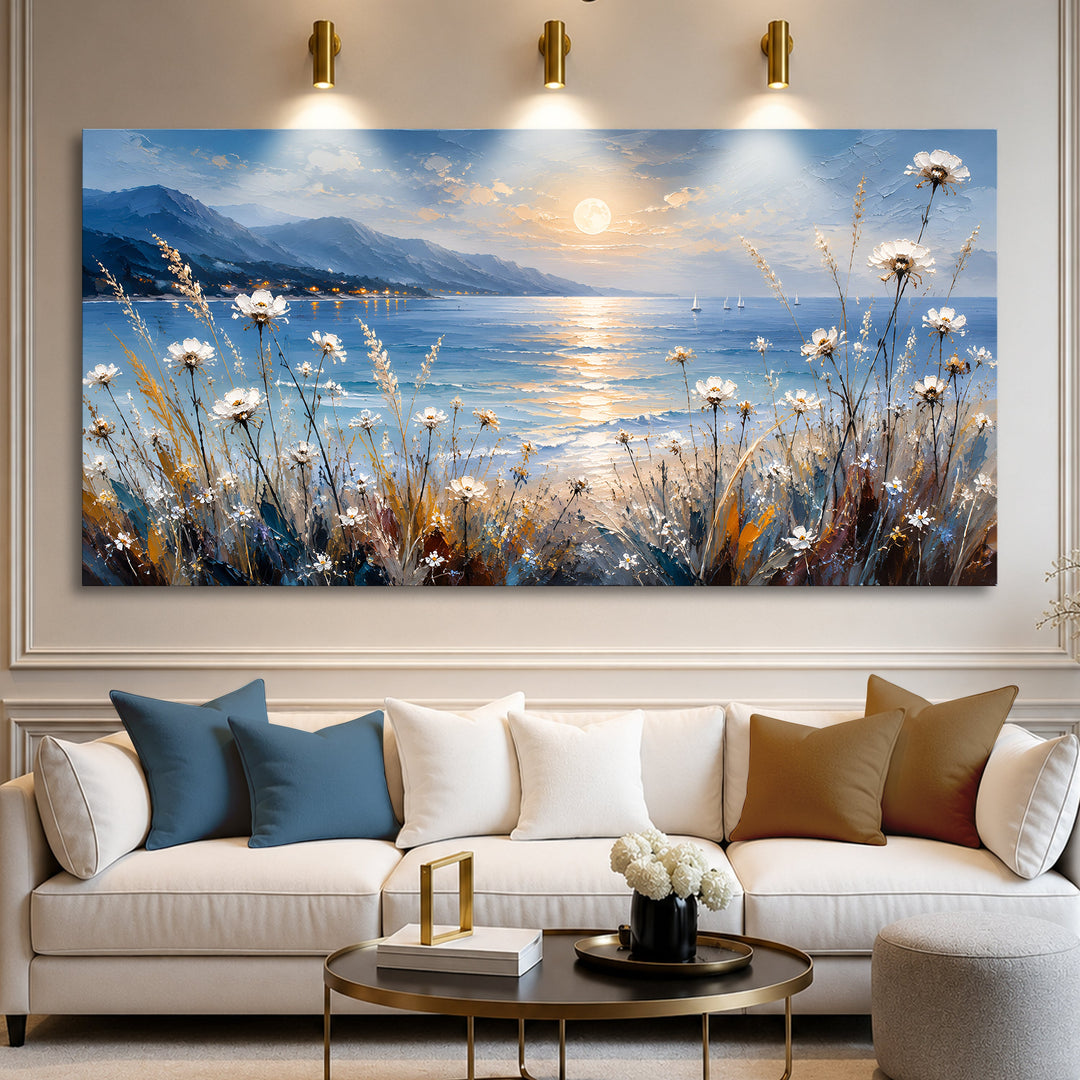 Quadro Luar à Beira-mar acima de sofá branco com almofadas azuis e caramelo e mesa de centro dourada