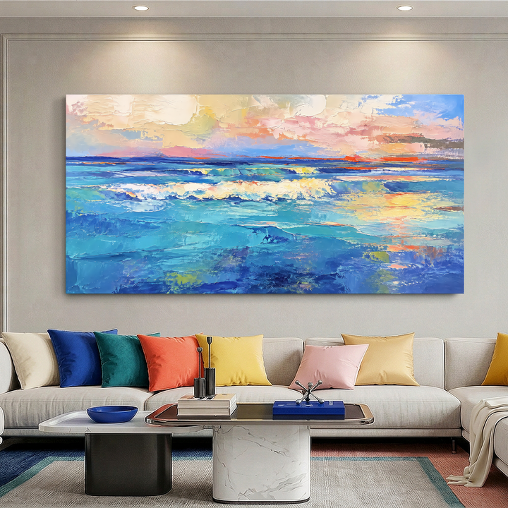 Quadro Mar ao Entardecer acima de sofá branco com almofadas coloridas e mesa de centro de mármore
