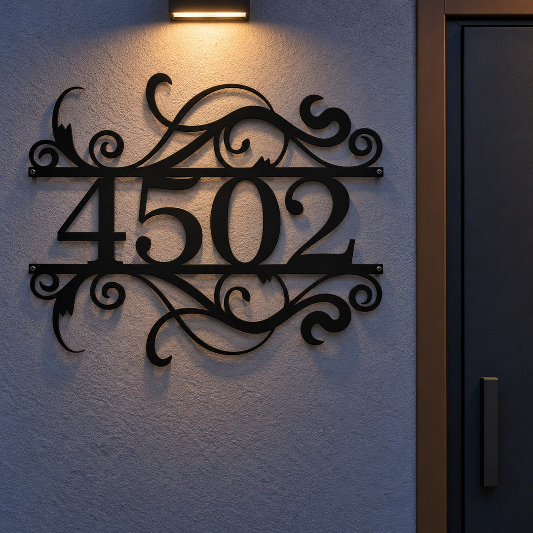 Placa Residencial Floral em metal preto no muro da casa à noite, iluminada por arandela